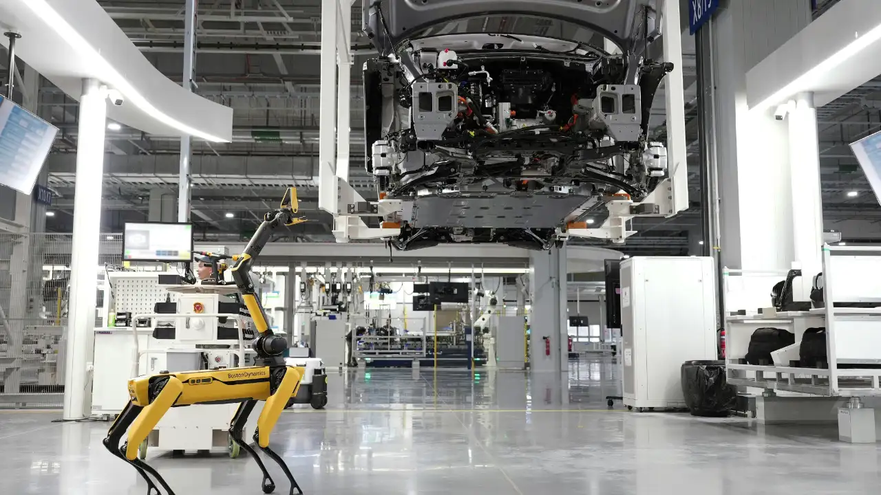 A robotic arm working on a car assembly line, representing technological advancements of national importance for an NIW.