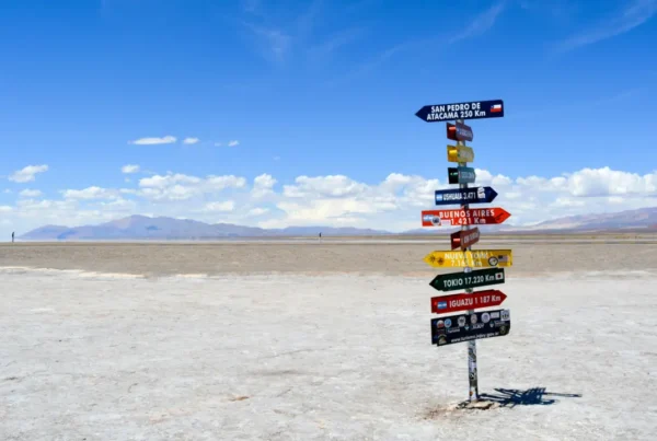 A professional man looking thoughtfully out an office window, considering the strategic choice between an NIW vs O-1 visa.