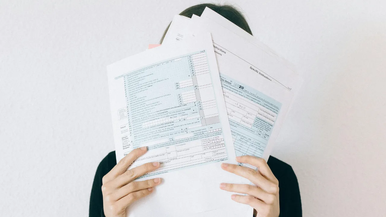 A person holding up financial documents, representing the process of E-2 visa due diligence.