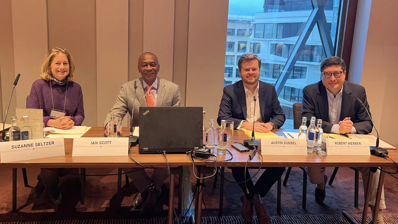 Four panelists—Suzanne Seltzer, Ian Scott, Justin Guebel, and Robert Webber—seated at a table for a discussion on the National Interest Waiver.
