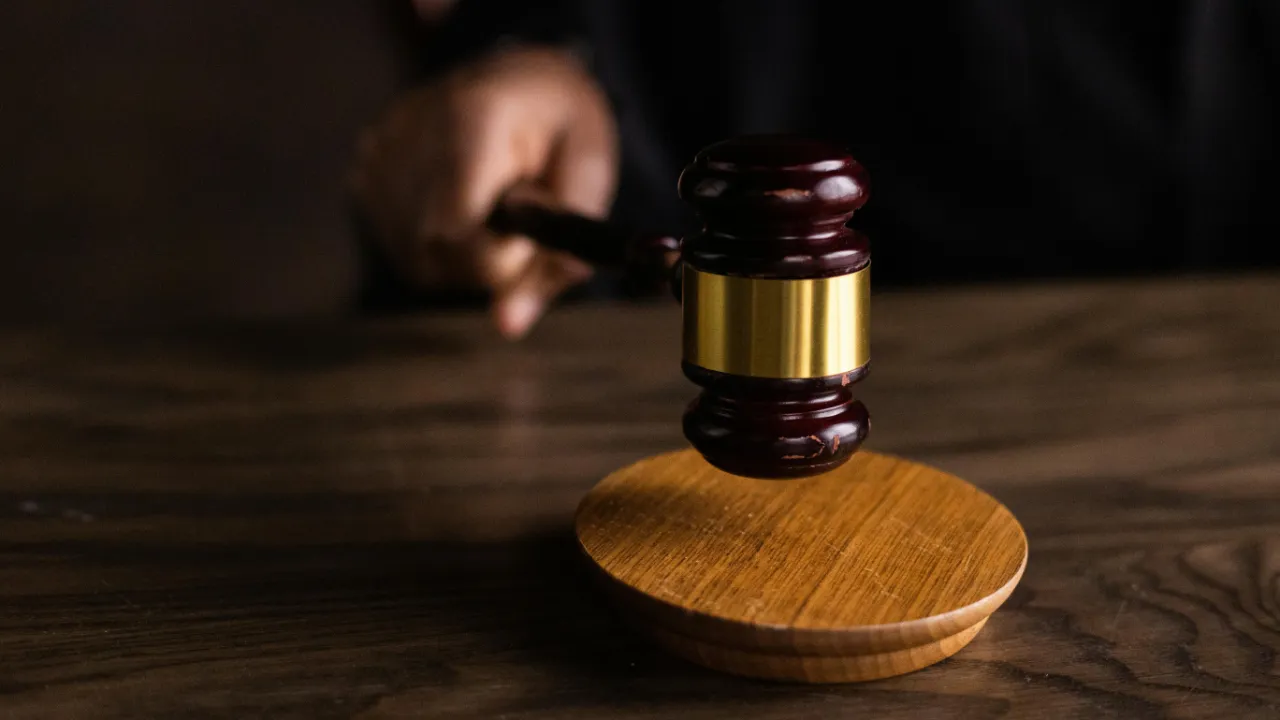 A judge's gavel hitting a sounding block, representing the legal action of suing for immigration delays.