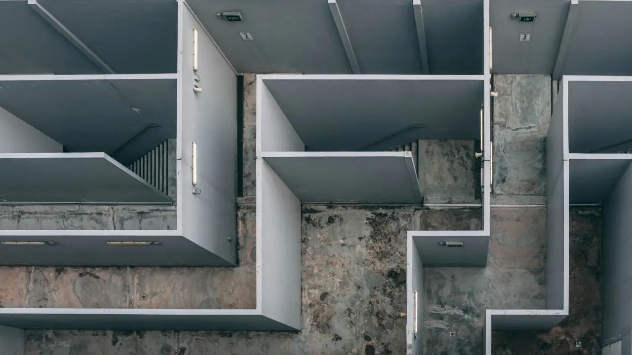 An overhead view of a complex concrete maze, symbolizing the strategic decision-making process between E-1 and E-2 visas.
