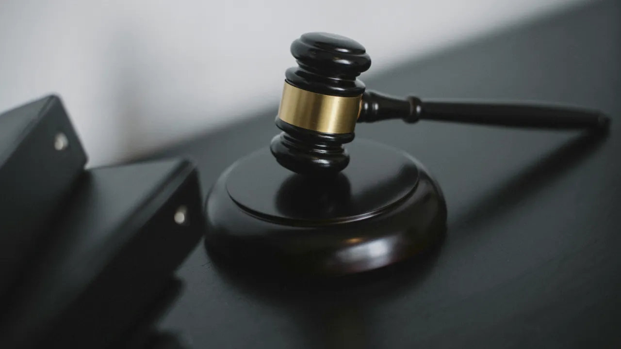 A close-up of a wooden gavel resting on a sound block, representing legal services and attorney fees.