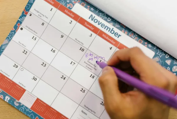 A person marking dates on a calendar, representing the six-month travel limit for U.S. permanent residents.