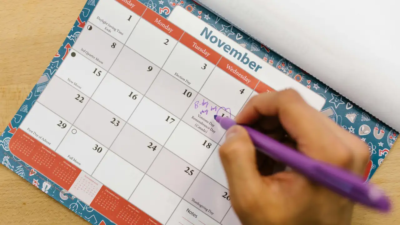 A person marking dates on a calendar, representing the six-month travel limit for U.S. permanent residents.
