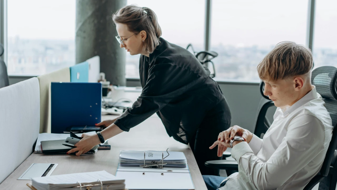 Professional team collaborating in a modern office environment, illustrating the role of an E-2 essential employee in a growing business.