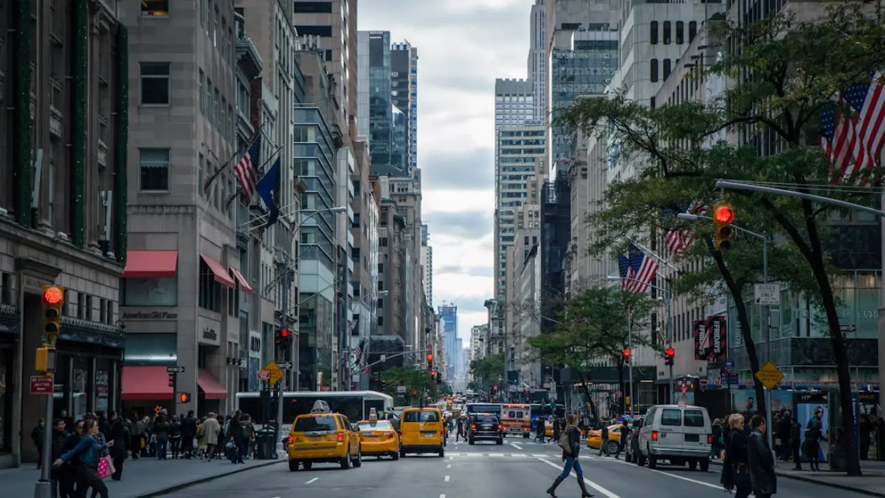 A view of the New York City skyline with Manhattan's skyscrapers and street traffic, representing paths to American residency and business opportunities.