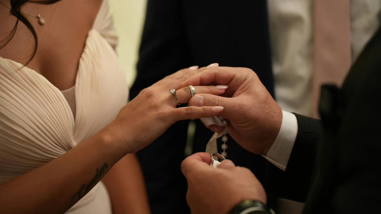 Close-up of two people exchanging wedding rings during a formal ceremony.