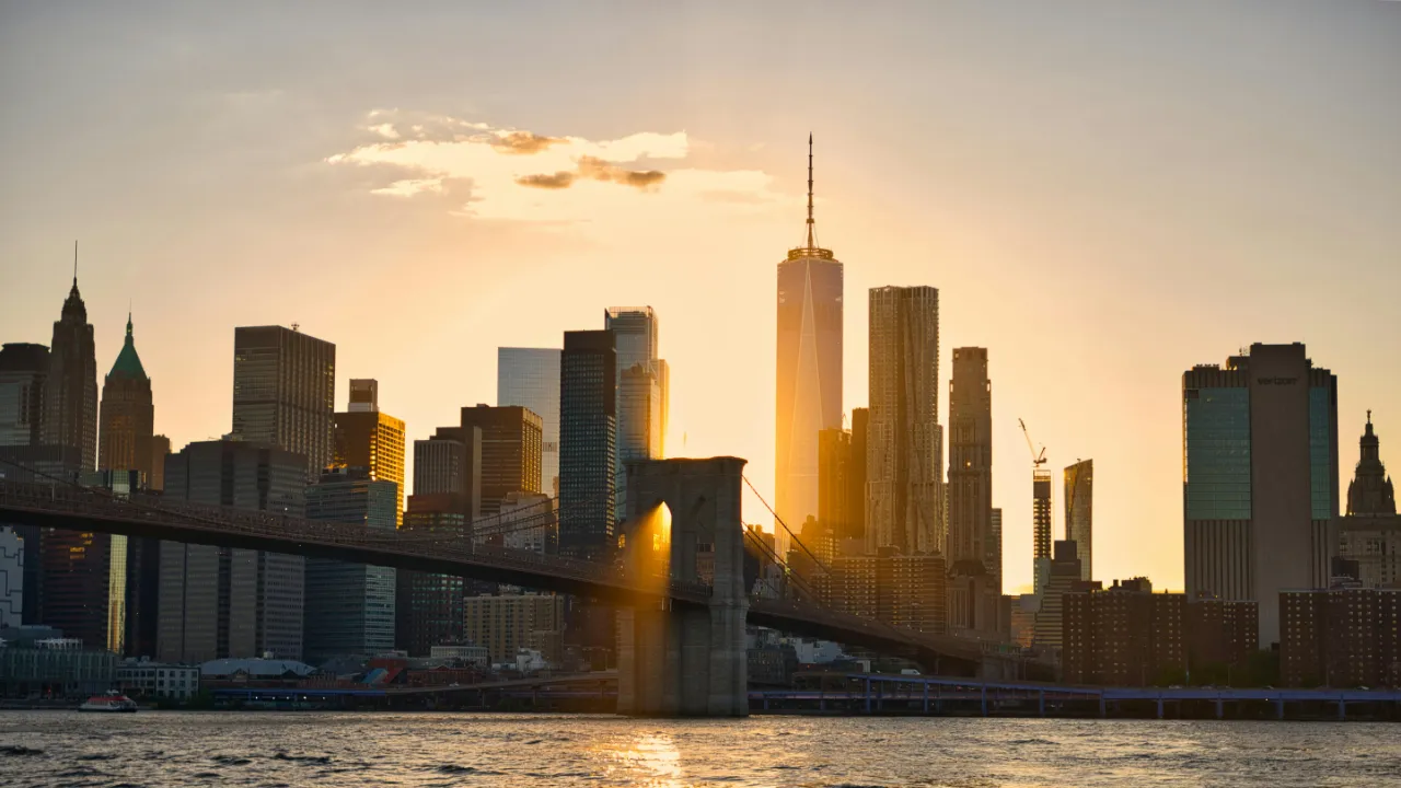 Sunset view of the New York City skyline and Brooklyn Bridge, symbolizing the path to an employment-based green card through USCIS in 2026.