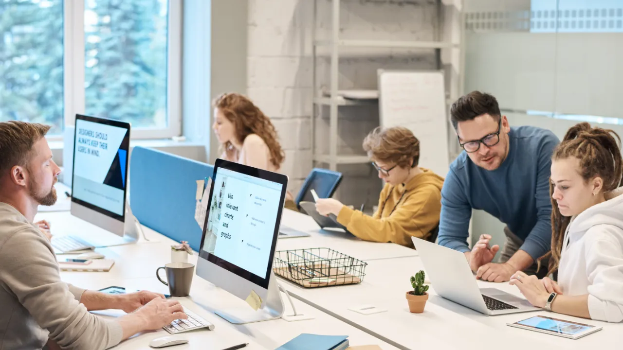 Employees collaborating at desks in an open-plan office at a software company