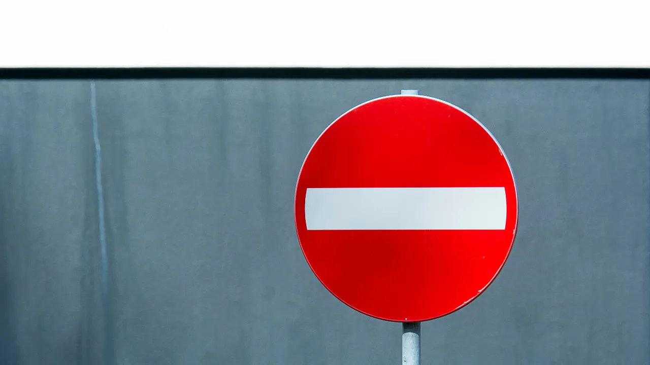 Red no entry road sign against a grey wall, representing an NIW petition denied on the third prong