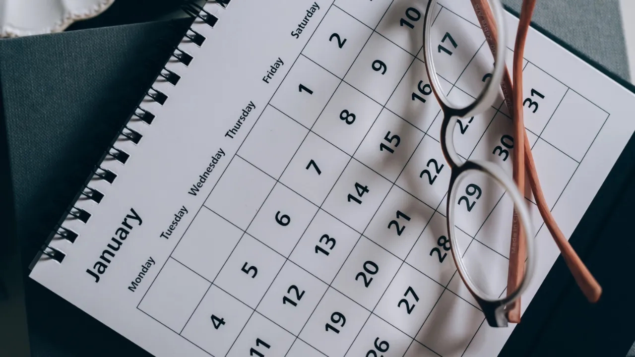 Desk calendar and reading glasses representing days counted toward the H-1B six-year limit