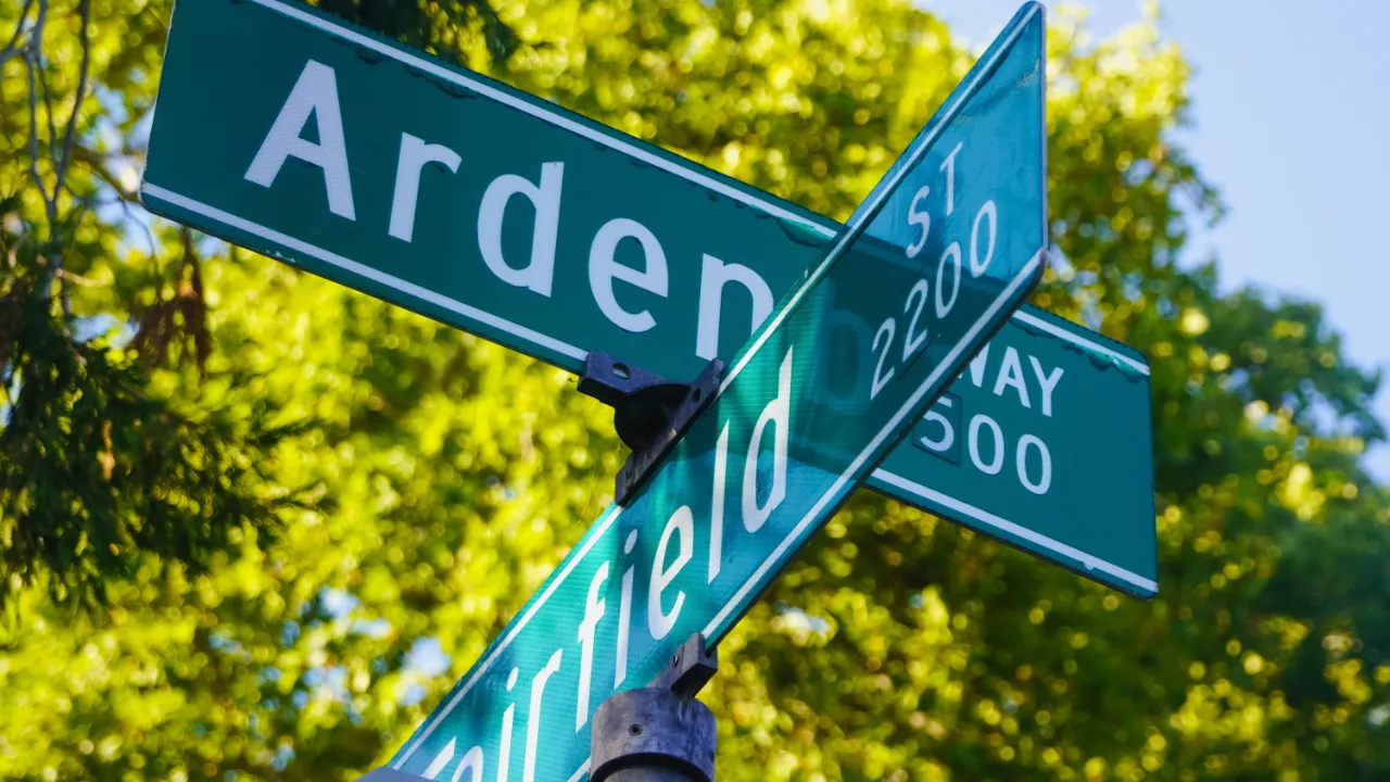 Green street name signs at an intersection, representing an L-1 company’s change of business address